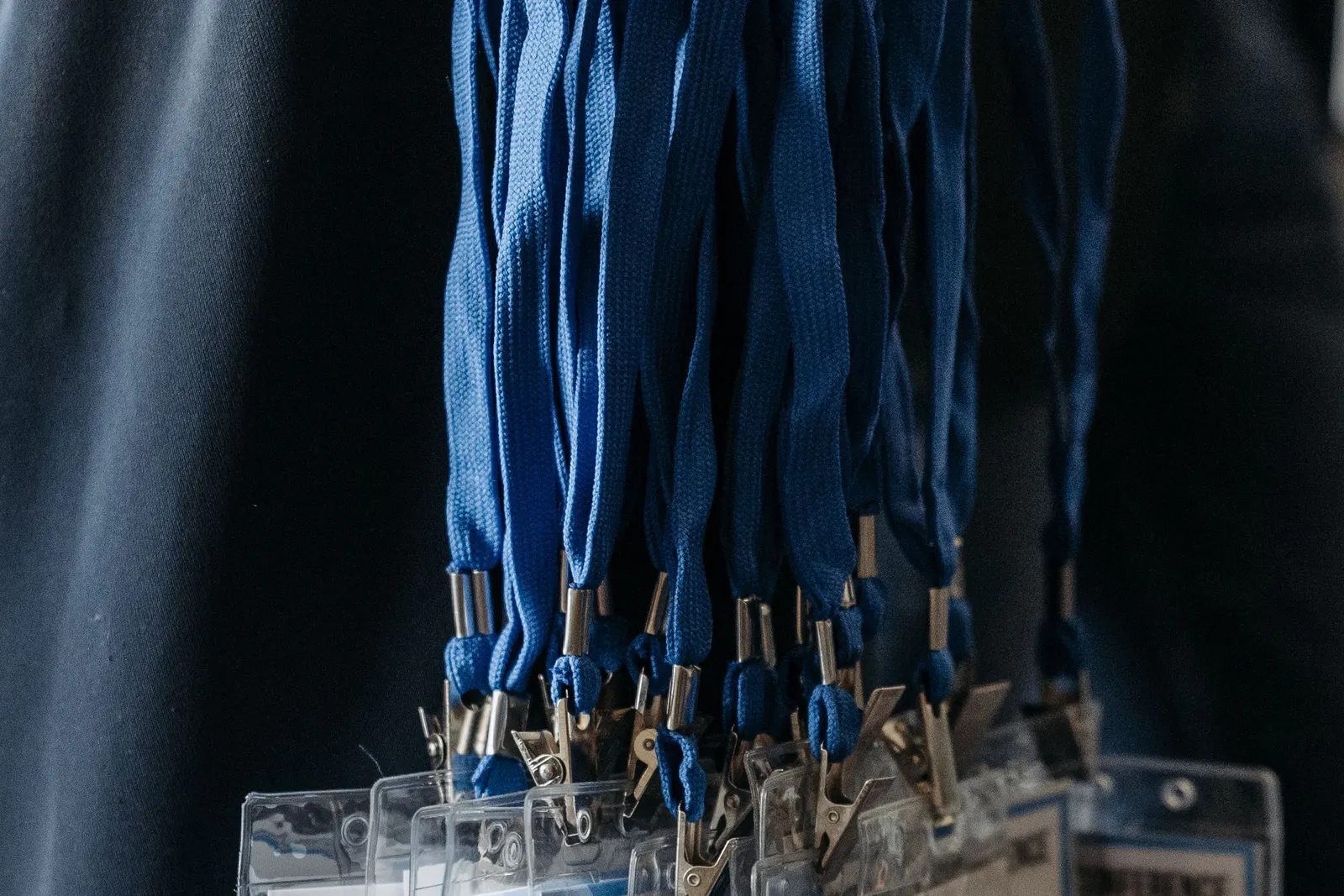 Blue fabric lanyards and metal clips prepared for event badges.
